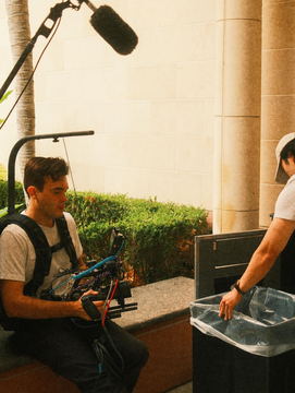 Javi seated in a courtyard garden wearing the camera support rig