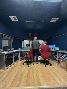Two people at the console of a mixing stage