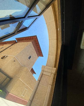 A building seen from below through a curved opening